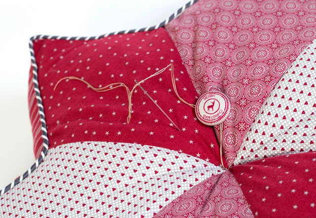 Nähanleitung Sternkissen beziehbaren Knopf annähen