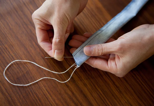 Täger wenden mit Nadel und Faden