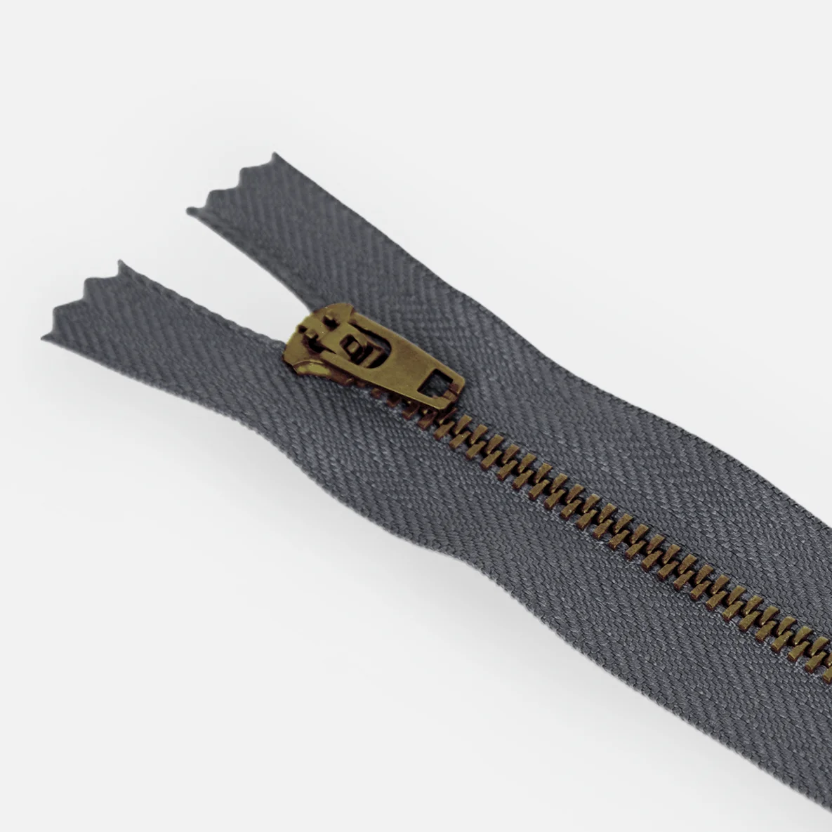 Detail von Jeans-Reißverschluss in Anthrazit mit Zähnchen in Messing