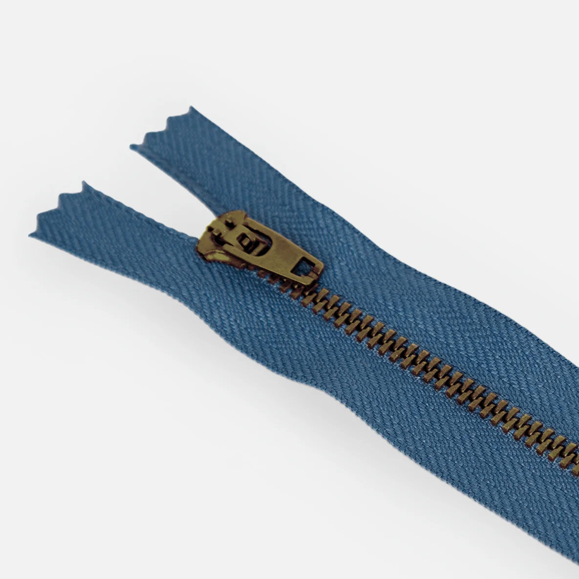 Detail von Jeans-Reißverschluss in Jeansblau mit Zähnchen in Messing