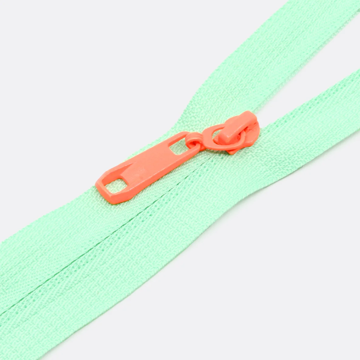 Rückseiten Reverse Zipper in Orange 4mm Perlonraupe auf mintfarbenem Endlos-Reißverschluss