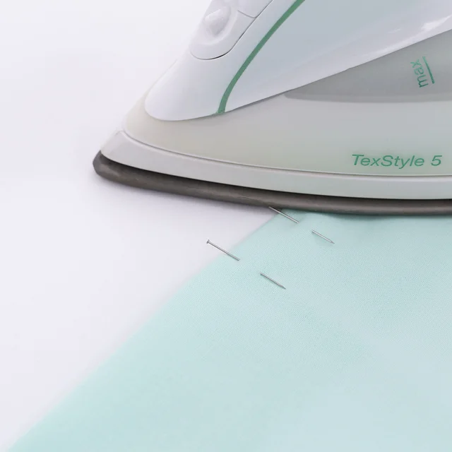 Über Stecknadeln bügeln